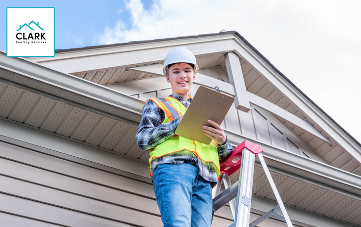 Person reviewing roof insurance claim estimate with paperwork.